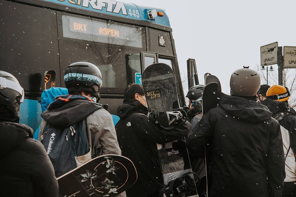Passengers loading a bus with their ski gear