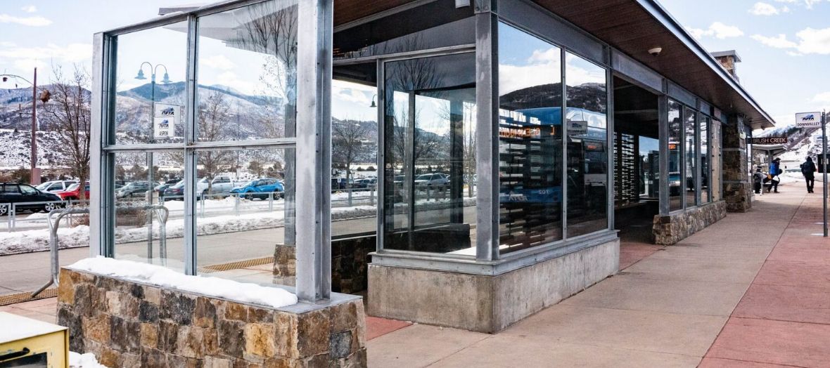 A large RFTA Bus stop with people walking past on a sunny but snowy day