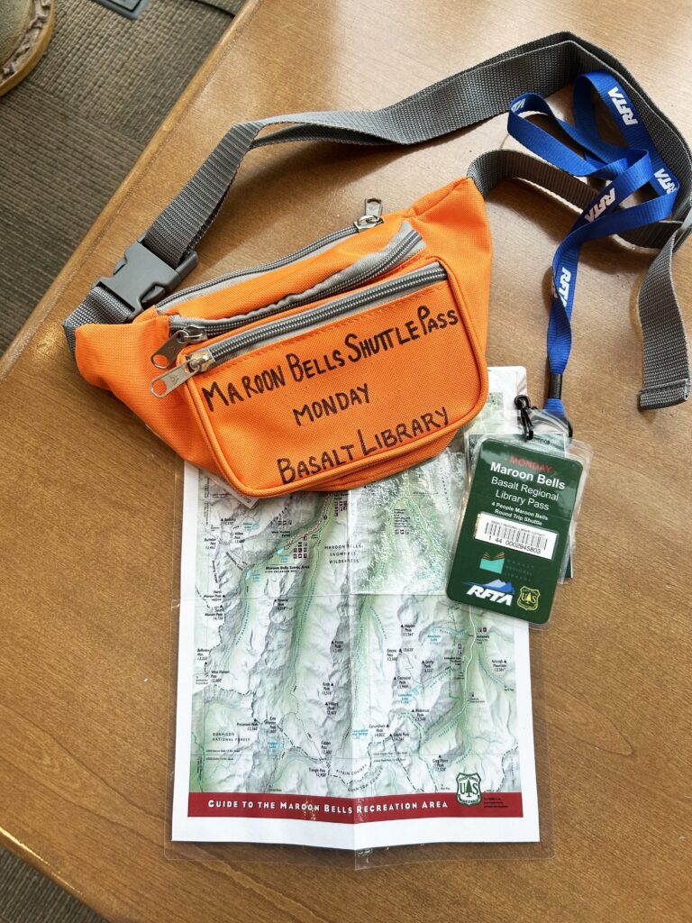 Fanny pack showing the Maroon Bells Scenic Shuttle Bus Map and pass that can be checked out from the Basalt Regional Library